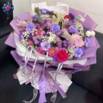 Gift Bouquet for Love with pink and purple flowers, lilies, carnations and gypsophila in elegant lilac wrapping.