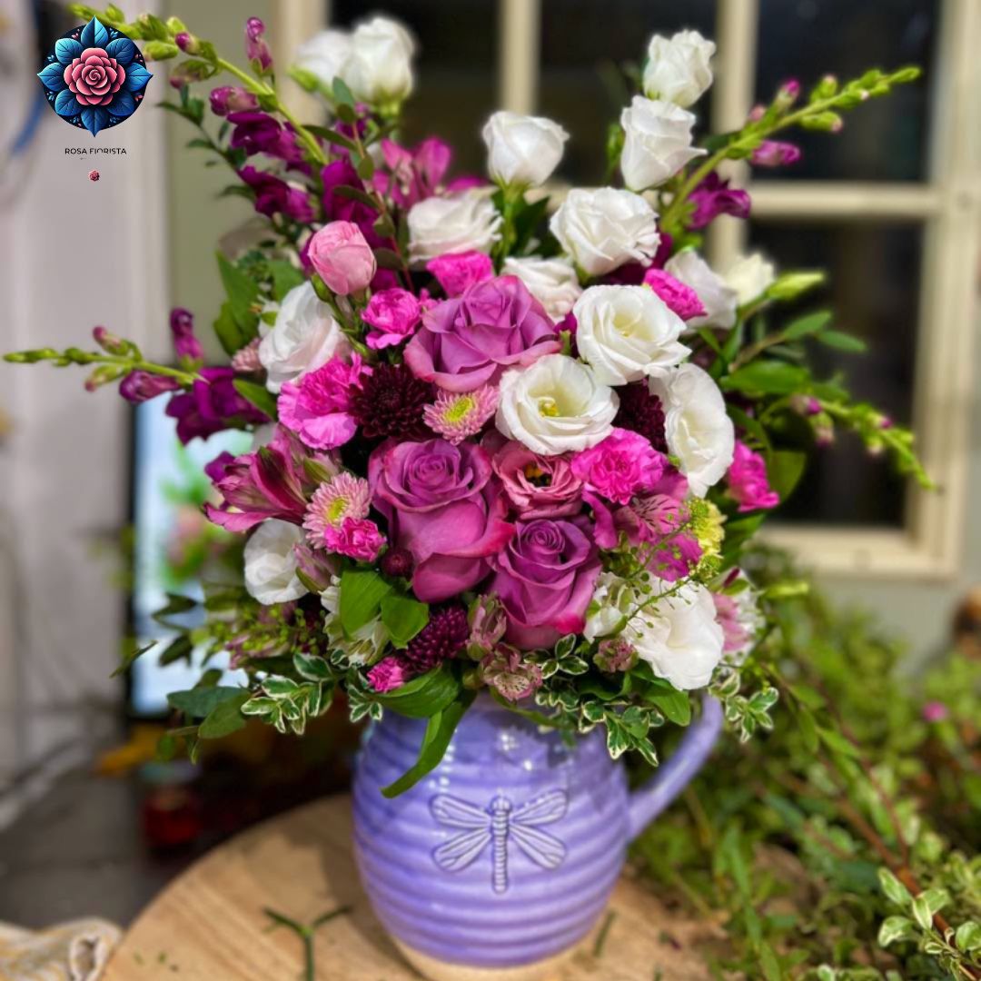 Mix Bouquet 032 with purple roses, white blooms, pink carnations and greenery in a lavender ceramic jug