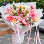 Mix Bouquet 036 featuring pink lilies, peach roses, pink gerberas, white gypsophila and elegant white wrapping in Milano.