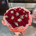 Rosa Rose Bouquet for gift with deep red roses, white gypsophila and peach-pink wrapping from Rosa Fiorista Milano.