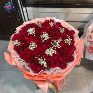Rosa Rose Bouquet for gift with deep red roses, white gypsophila and peach-pink wrapping from Rosa Fiorista Milano.